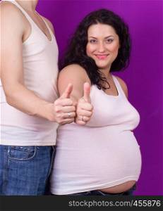 pregnancy - a man and a pregnant woman posing on a purple background