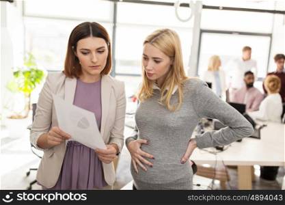 pregnancy and people concept - business team with papers in office. business team with papers in office