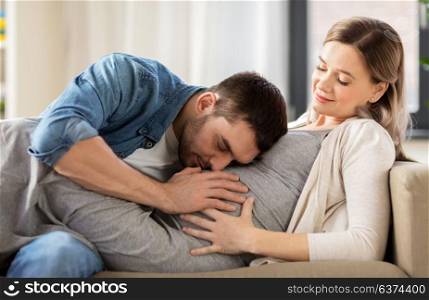 pregnancy and people concept - happy man with pregnant woman at home. happy man with pregnant woman at home