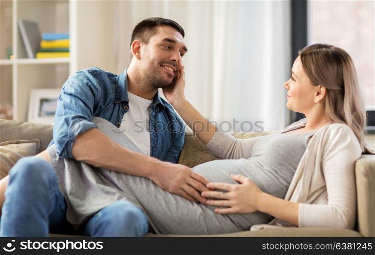 pregnancy and people concept - happy man with pregnant woman at home. happy man with pregnant woman at home