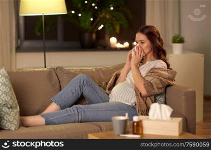 pregnancy and people concept - sick pregnant woman blowing nose with paper tissue at home. sick pregnant woman blowing nose at home