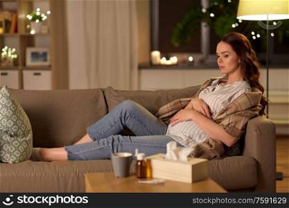 pregnancy and people concept - sick pregnant woman on sofa at home. sick pregnant woman on sofa at home