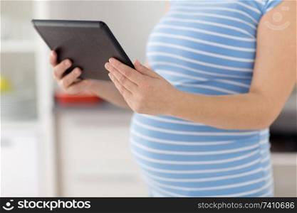 pregnancy and technology concept - close up of pregnant woman with tablet computer. close up of pregnant woman with tablet computer
