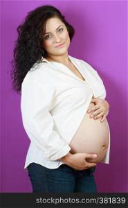 pregnancy - beautiful pregnant woman posing on a purple background