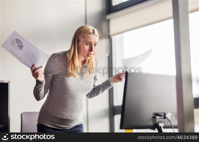 pregnancy, business, stress, people and work concept - angry pregnant businesswoman with papers and computer at office
