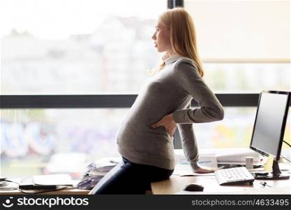 pregnancy, business, work and people concept - pregnant businesswoman looking through window at office