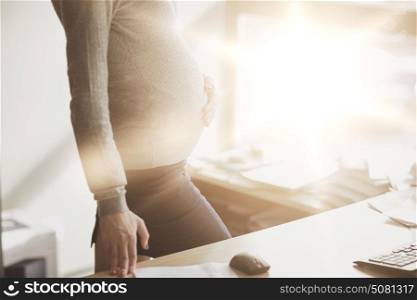 pregnancy, business, work and people concept - pregnant businesswoman looking through window at office. pregnant businesswoman with computer at office