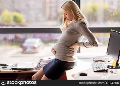 pregnancy, business, work and people concept - pregnant businesswoman touching back and belly at office