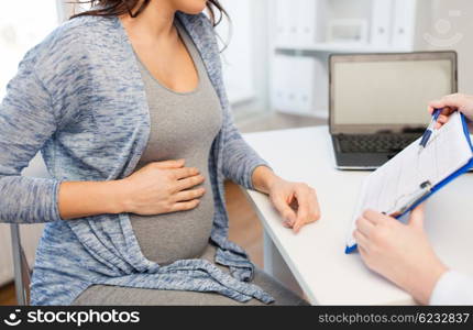 pregnancy, cardiology, medicine, health care and people concept - close up of cardiologist doctor showing cardiogram to pregnant woman meeting at hospital