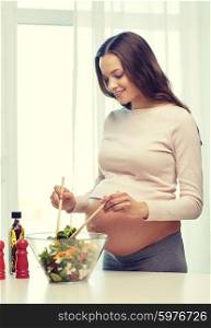 pregnancy, cooking food, healthy lifestyle, people and expectation concept - happy pregnant woman mixing vegetable salad in bowl at home
