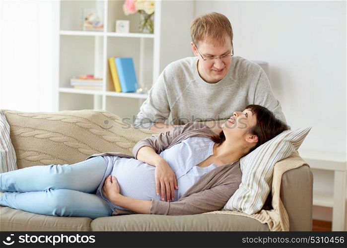 pregnancy, family and people concept - happy pregnant wife with husband at home. happy pregnant wife with husband at home