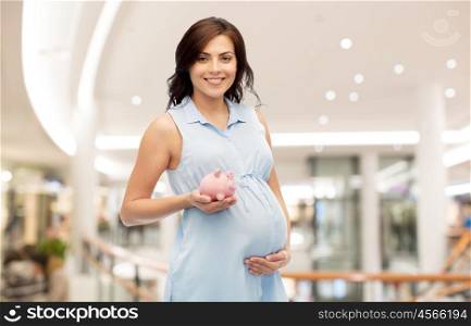 pregnancy, finance, saving, shopping and people concept - happy pregnant woman with piggybank over mall background