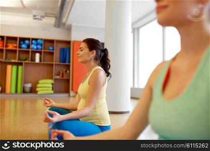 pregnancy, fitness, people and healthy lifestyle concept - group of happy pregnant women meditating in lotus pose at gym yoga. happy pregnant women meditating at gym yoga. happy pregnant women meditating at gym yoga