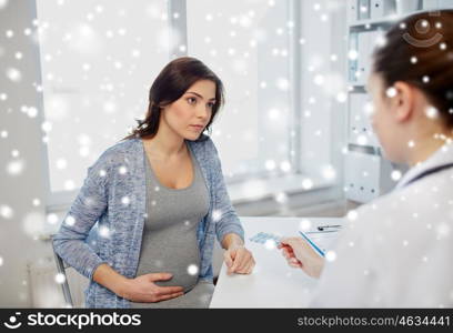 pregnancy, gynecology, medicine, healthcare and people concept - doctor and pregnant woman meeting at hospital over snow