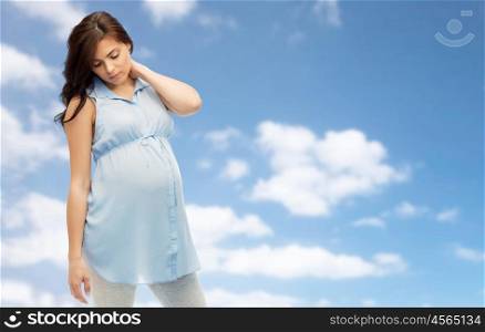 pregnancy, health, people and expectation concept - pregnant woman in bed touching her back and suffering from neckache over blue sky background