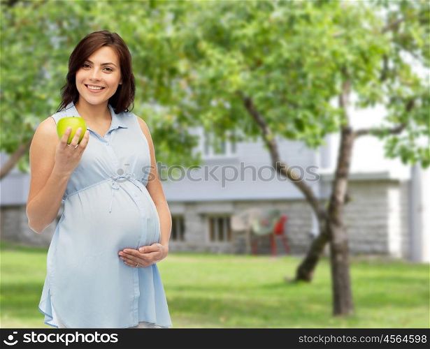 pregnancy, healthy eating, food and people concept - happy pregnant woman holding green apple over summer garden and house background