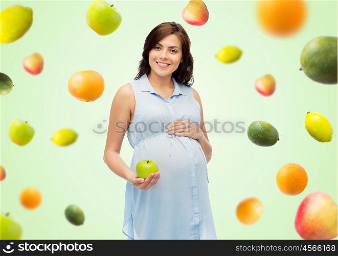pregnancy, healthy eating, food and people concept - happy pregnant woman holding green apple over green natural background with fruits