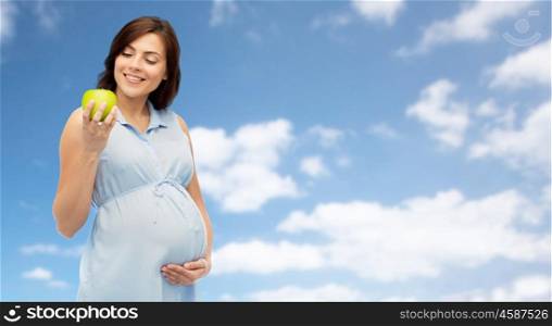 pregnancy, healthy eating, food and people concept - happy pregnant woman holding green apple over blue sky background