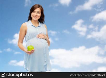 pregnancy, healthy eating, food and people concept - happy pregnant woman holding green apple over blue sky and clouds background
