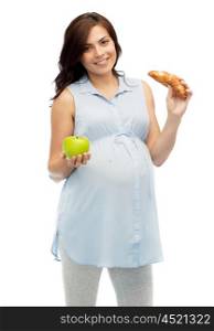 pregnancy, healthy eating, junk food and people concept - happy pregnant woman choosing between green apple and croissant over white background