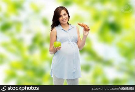 pregnancy, healthy eating, junk food and people concept - happy pregnant woman choosing between green apple and croissant over green natural background
