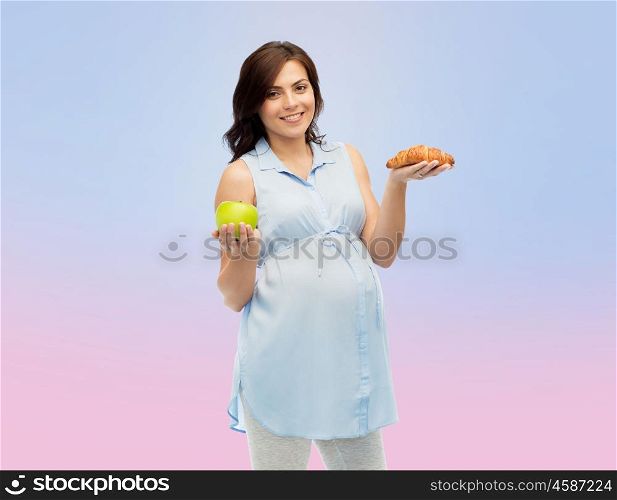 pregnancy, healthy eating, junk food and people concept - happy pregnant woman choosing between green apple and croissant over rose quartz and serenity gradient background