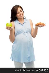 pregnancy, healthy eating, junk food and people concept - happy pregnant woman choosing between green apple and croissant over white background