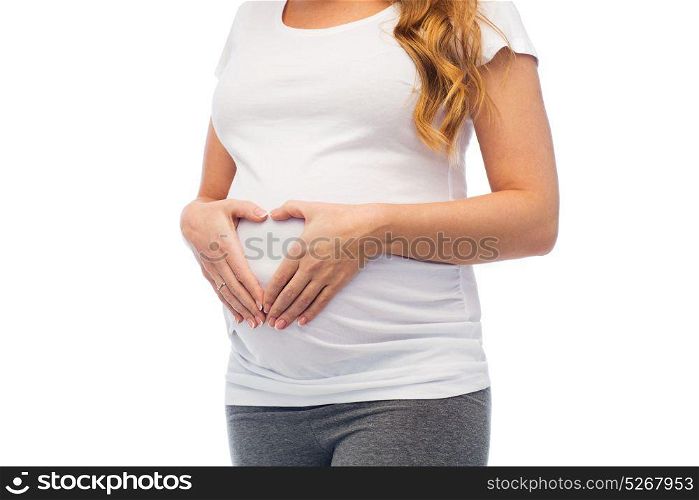 pregnancy, love and people concept - close up of pregnant woman making heart gesture on her belly. pregnant woman making heart gesture on her belly