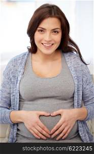 pregnancy, love, people and expectation concept - happy pregnant woman making heart gesture at home