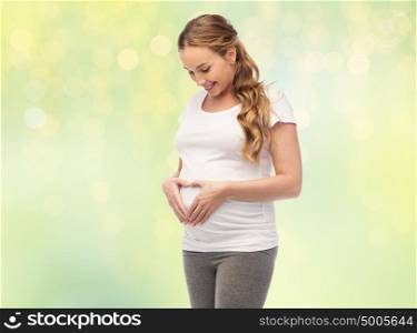 pregnancy, love, people and expectation concept - happy pregnant woman showing heart gesture over summer green lights background. happy pregnant woman showing heart gesture