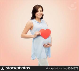 pregnancy, love, people and expectation concept - happy pregnant woman with red heart shape touching her belly over beige background