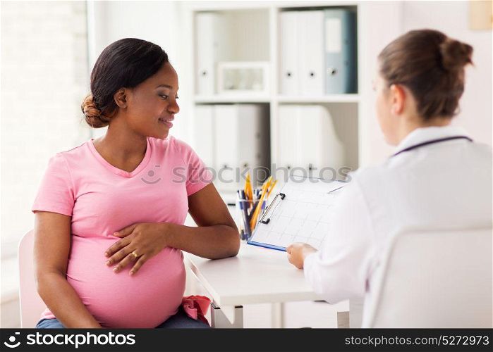 pregnancy, medicine, healthcare and people concept - cardiologist doctor showing cardiogram to pregnant african american woman meeting at hospital. cardiologist and pregnant woman at hospital