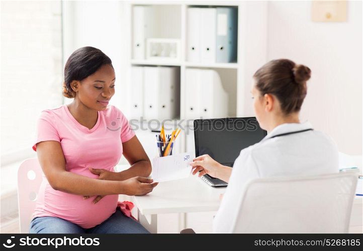 pregnancy, medicine, healthcare and people concept - gynecologist doctor giving prescription to pregnant african american woman at hospital. gynecologist doctor and pregnant woman at hospital