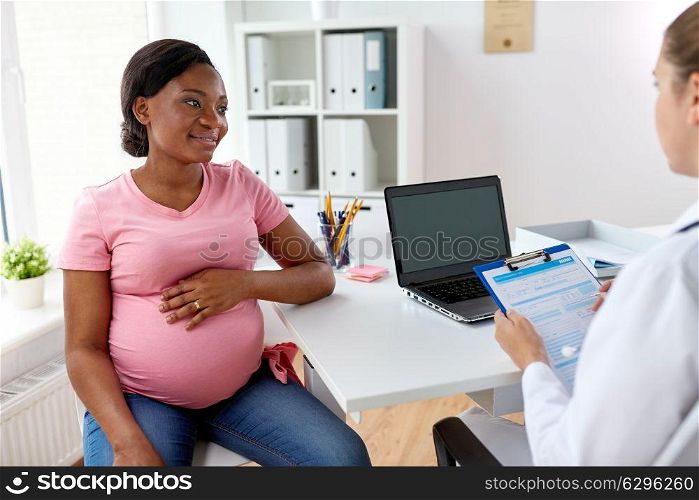 pregnancy, medicine, healthcare and people concept - gynecologist doctor with clipboard and happy smiling pregnant african american woman meeting at hospital. gynecologist and happy pregnant woman at hospital