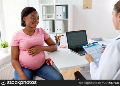 pregnancy, medicine, healthcare and people concept - gynecologist doctor with clipboard and happy smiling pregnant african american woman meeting at hospital. gynecologist and happy pregnant woman at hospital