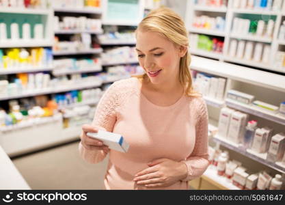pregnancy, medicine, people, healthcare and expectation concept - happy pregnant woman with medication at pharmacy. happy pregnant woman with medication at pharmacy