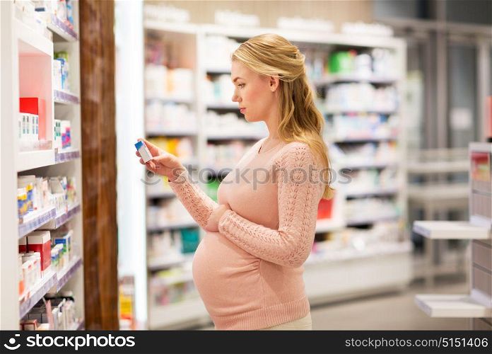 pregnancy, medicine, people, healthcare and expectation concept - happy pregnant woman with medication at pharmacy. happy pregnant woman with medication at pharmacy