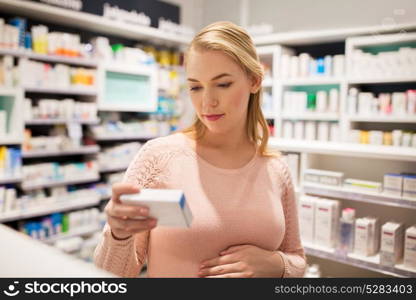 pregnancy, medicine, people, healthcare and expectation concept - happy pregnant woman with medication at pharmacy. happy pregnant woman with medication at pharmacy