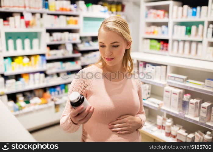pregnancy, medicine, people, healthcare and expectation concept - happy pregnant woman with medication jar at pharmacy. happy pregnant woman with medication at pharmacy