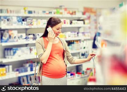 pregnancy, medicine, pharmaceutics, health care and people concept - happy pregnant woman calling on smartphone and choosing medication at pharmacy