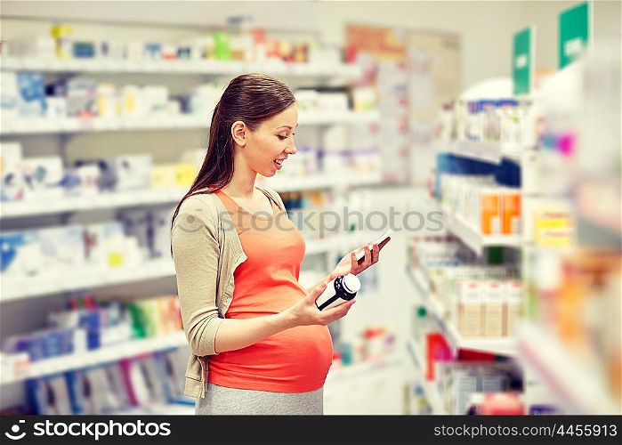 pregnancy, medicine, pharmaceutics, health care and people concept - happy pregnant woman with smartphone choosing medication at pharmacy