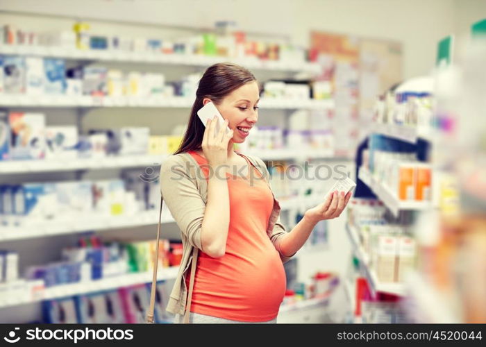 pregnancy, medicine, pharmaceutics, health care and people concept - happy pregnant woman calling on smartphone and choosing medication at pharmacy