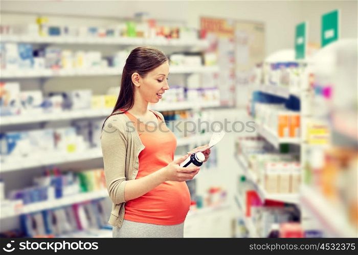 pregnancy, medicine, pharmaceutics, health care and people concept - happy pregnant woman with medication reading prescription paper at pharmacy