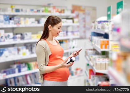 pregnancy, medicine, pharmaceutics, health care and people concept - happy pregnant woman with smartphone choosing medication at pharmacy