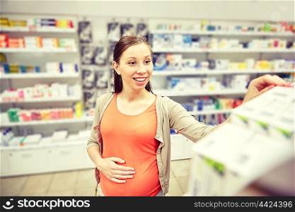 pregnancy, medicine, pharmaceutics, health care and people concept - happy pregnant woman choosing medication at pharmacy
