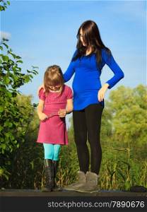 Pregnancy, motherhood and children upbringing. pregnant woman outdoor in park with little girl. Mother and daughter having relationship difficulties