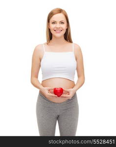 pregnancy, motherhood and happiness concept - happy future mother holding small red heart