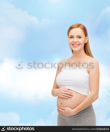 pregnancy, motherhood and happiness concept - happy future mother touching her belly