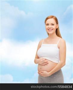 pregnancy, motherhood and happiness concept - happy future mother touching her belly
