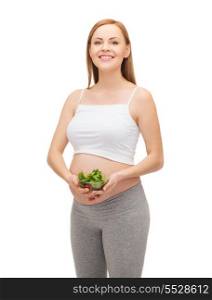 pregnancy, motherhood and happiness concept - happy future mother with bowl of salad